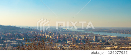 A panoramic cityscape with bridges, a winding river, and distant hills under a hazy golden sky. A panoramic cityscape with bridges, a winding river, and distant hills under a hazy golden sky. 124077925