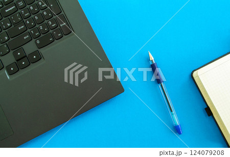 desktop. Laptop, notepad and pen on a blue background. desktop. Laptop, notepad and pen on a blue background. 124079208