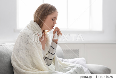 Covid-19 infection. Sick young woman coughing at home, empty space Covid-19 infection. Sick young woman coughing at home, empty space 124081020