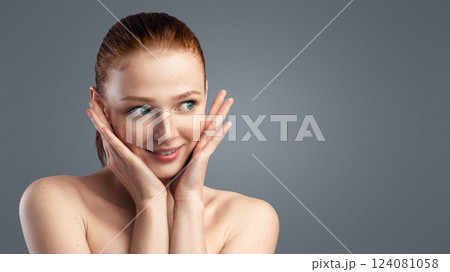 Attractive Young Woman Touching Face Posing Wrapped In Towel After Shower And Skincare Routine Standing Over Gray Studio Background. Facial Skin Care Products Advert Concept. Panorama, Free Space 124081058