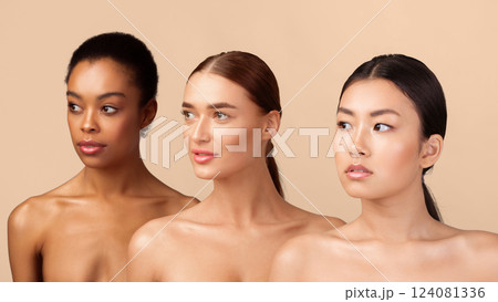 Beauty. Portrait of three diverse millennial girls posing shirtless standing in studio on gray background. Panorama 124081336