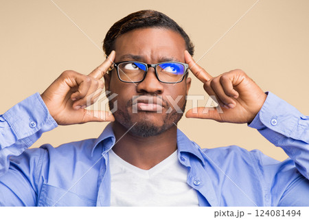 Creative Thinking. Thoughtful Black Man Concentrating Hard On An Idea Pointing Fingers At Forehead Standing On Yellow Background Creative Thinking. Thoughtful Black Man Concentrating Hard On An Idea Pointing Fingers At Forehead Standing On Yellow Background 124081494