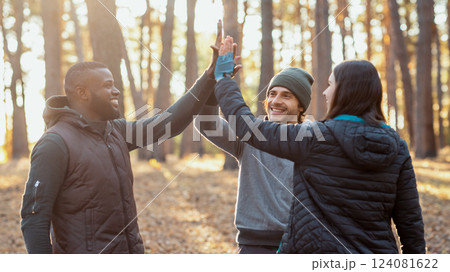 Cheerful multiracial friends gathering hands up together over camping tent, teamwork concept 124081622