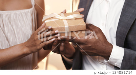 Valentine's surprise. Cropped of african man and woman holding gift box, having dinner at restaurant 124081714