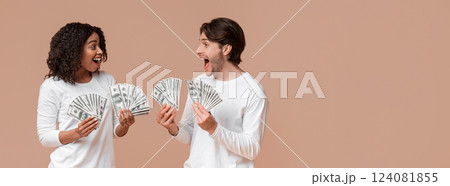 Lucky interracial couple holding bunch of dollar cash in hands, celebrating big win together, won a lottery, made successful investment, yellow background Lucky interracial couple holding bunch of dollar cash in hands, celebrating big win together, won a lottery, made successful investment, yellow background 124081855