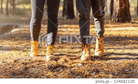 Hiking together. Couple of tourists crossing forest in autumn, cropped Hiking together. Couple of tourists crossing forest in autumn, cropped 124082120