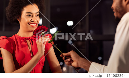 Valentine's Romance. African American Man Giving Rose To Girlfriend Having Romantic Date In Restaurant In Evening. Panorama Valentine's Romance. African American Man Giving Rose To Girlfriend Having Romantic Date In Restaurant In Evening. Panorama 124082264