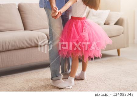 Little princess daughter standing on father feet, looking up and dancing, fatherhood, parenthood concept Little princess daughter standing on father feet, looking up and dancing, fatherhood, parenthood concept 124082348