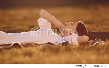 Illuminated by sunlight. Young girl is on the field at daytime having nice weekend Illuminated by sunlight. Young girl is on the field at daytime having nice weekend 124083064