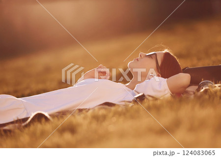 Illuminated by sunlight. Young girl is on the field at daytime having nice weekend Illuminated by sunlight. Young girl is on the field at daytime having nice weekend 124083065