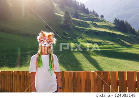 Cute young little kid girl boy wear cat furry mask enjoy have fun playing outdoors alpine valley street park. Child therian wild animal character trendy fan culture. Teenager social expression hobby 124083149