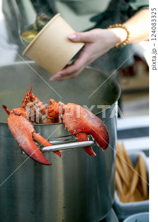 European street food festival. Large pot seafood soup displayed market counter cooked lobster balanced edge. Customers gathered around examining delicious seafood broth market setting restaurant European street food festival. Large pot seafood soup displayed market counter cooked lobster balanced edge. Customers gathered around examining delicious seafood broth market setting restaurant 124083325
