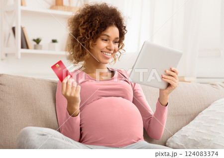 Excited pregnant woman buying goods for newborn, using tablet and credit card Excited pregnant woman buying goods for newborn, using tablet and credit card 124083374