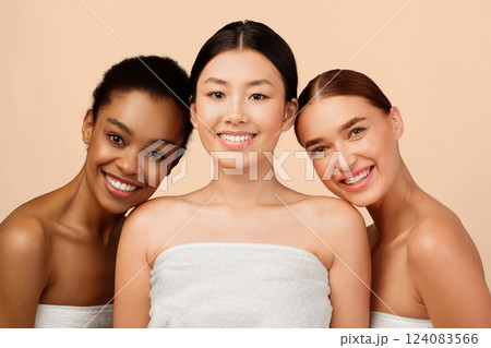 Female Beauty Concept. Three Mixed Girls Wrapped In Towels Smiling To Camera Posing In Studio On White Background. 124083566