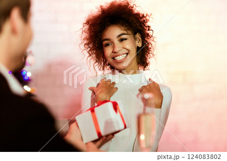 Christmas Gift. Guy Giving Girlfriend Xmas Wrapped Present Box Celebrating Holidays Together Standing Indoor 124083802