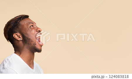 Anger. Aggressive Black Guy Screaming Loudly Standing Over Yellow Background In Studio. Panorama, Copy Space, Side View 124083818