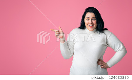 Fashion Clothes For Overweight People Concept. Excited Plump Woman Pointing Aside At Copy Space Over Pink Background, Panorama 124083850