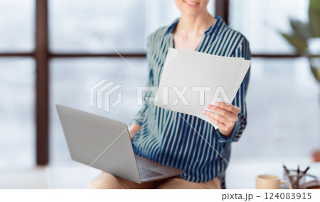 Business Accounting. Unrecognizable Lady Holding Laptop And Documents Sitting In Modern Office. Cropped, Shallow Depth, Selective Focus Business Accounting. Unrecognizable Lady Holding Laptop And Documents Sitting In Modern Office. Cropped, Shallow Depth, Selective Focus 124083915