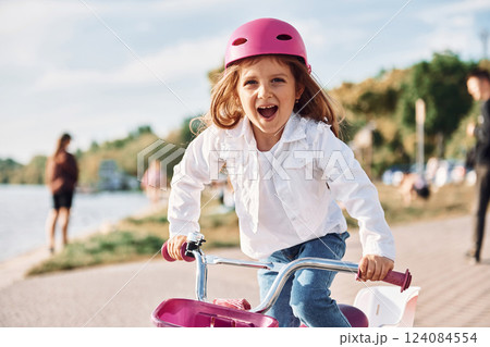 Moving fast. Happy little girl riding a bicycle outdoors in summer Moving fast. Happy little girl riding a bicycle outdoors in summer 124084554