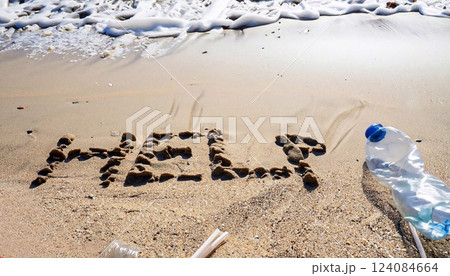 Help message written on the beach next to plastic waste 124084664