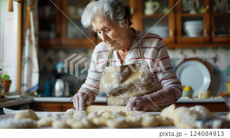 A senior woman rolls dough in her neat kitchen, the state pension giving her peace and financial security. 124084913
