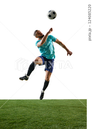 Football player mid-air skillfully heading ball, body control in motion, intense focus on trajectory. Dynamic shot. Football player mid-air skillfully heading ball, body control in motion, intense focus on trajectory. Dynamic shot. 124085220