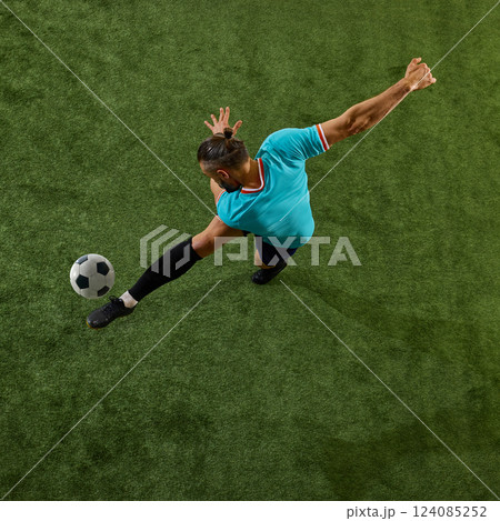 Intense moment of footballer preparing for winning shot, body arched, balance maintained, eyes locked on target. Intense moment of footballer preparing for winning shot, body arched, balance maintained, eyes locked on target. 124085252