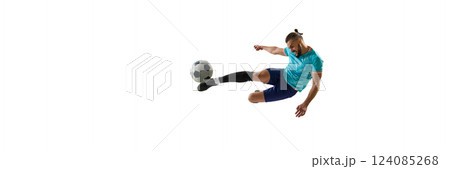 Banner. Focused athlete executing powerful kick, body suspended in air, eyes locked on ball, showcasing agility on stadium field. 124085268