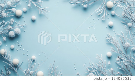 A decorative layout featuring snowy branches and white spheres prominently displayed against a soft blue backdrop, creating a winter atmosphere. The arrangement highlights the beauty of the season. 124085533