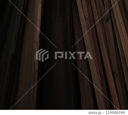 立て掛けられた黒褐色のたくさんの材木の背景画像 124086399