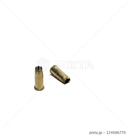 gunpowder charge for powder-actuated concrete nail gun. pair of used .22-caliber blank shell. isolated on white background gunpowder charge for powder-actuated concrete nail gun. pair of used .22-caliber blank shell. isolated on white background 124086770