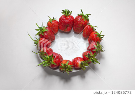 delicious bright fresh red strawberries, arranged at the edge of small porcelain plate 124086772