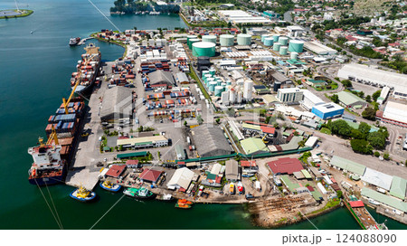 A port with stacked shipping containers, industrial buildings, and cargo ships on the coastline. Victoria. Seychelles, Mahe. 124088090