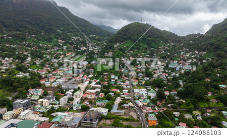 A dense urban sprawl of homes sits within a lush green valley, surrounded by forested hills. Victoria city. Mahe, Seychelles. A dense urban sprawl of homes sits within a lush green valley, surrounded by forested hills. Victoria city. Mahe, Seychelles. 124088103