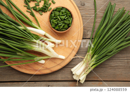 Cut green onion on grey wooden background. Cut green onion on grey wooden background. 124088559