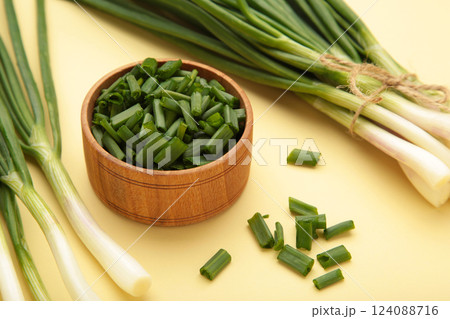 Cut green onion on a beige background. Cut green onion on a beige background. 124088716