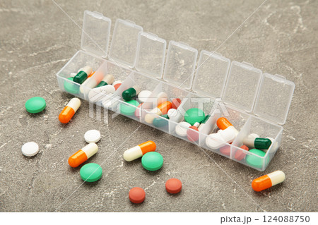 Daily pill box with medications and nutritional supplements on grey background. 124088750