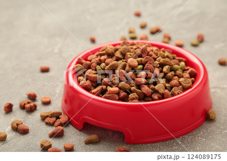 Pet food in red bowl on grey background. 124089175
