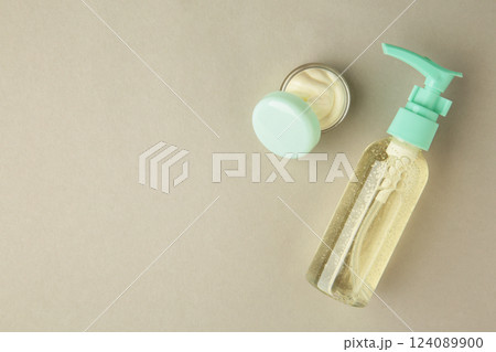 Facial cosmetic cream in transparent open jar, beauty product on grey background. Space for text 124089900