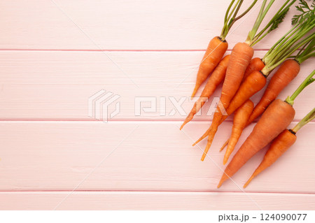Bunch of baby carrots on pink background. Space for text 124090077