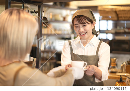 コーヒーカップを手渡すカフェ店員 コーヒーカップを手渡すカフェ店員 124090115