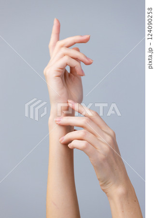 Elegant Display of Human Hands with an Artistic Focus on Graceful Movements and Soft Features Against a Minimalistic Background 124090258