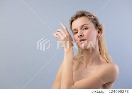 Captivating Portrait of a Woman Gesturing Elegantly Under Soft Natural Light Against a Muted Background, Highlighting Her Natural Beauty and Graceful Expression Captivating Portrait of a Woman Gesturing Elegantly Under Soft Natural Light Against a Muted Background, Highlighting Her Natural Beauty and Graceful Expression 124090278