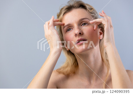 A Woman Engaged in a Facial Self-Care Routine Demonstrating Skincare Techniques for Youthful Appearance and Healthier Skin in a Soft Color Palette A Woman Engaged in a Facial Self-Care Routine Demonstrating Skincare Techniques for Youthful Appearance and Healthier Skin in a Soft Color Palette 124090395