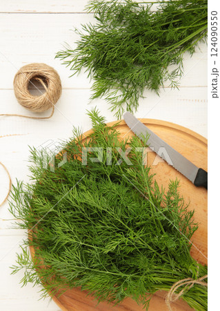 Cut dill on cutting board on white background. Vertical photo 124090550