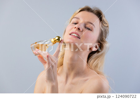 Elegant woman gracefully applying luxurious perfume, highlighting beauty and sophistication in a serene and stylish portrait showcasing confidence and allure with fragrance experience. Elegant woman gracefully applying luxurious perfume, highlighting beauty and sophistication in a serene and stylish portrait showcasing confidence and allure with fragrance experience. 124090722