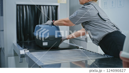 TSA Officer Taking Pet Carriers Moving from X-ray Metal Detector Scanner After Checking TSA Officer Taking Pet Carriers Moving from X-ray Metal Detector Scanner After Checking 124090827