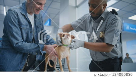 Airport Terminal: TSA Officer Inspecting Dog with Metal Detector 124090856