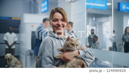 Airport Terminal: Portrait of Smiling Woman Holding Cat in Hands, Looking at Camera 124090920