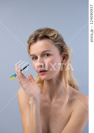 Captivating Portrait of a Woman Holding Colorful Makeup Tools, Emphasizing Beauty and Creativity, Illustrating the Art of Makeup Application in a Relaxed Atmosphere Captivating Portrait of a Woman Holding Colorful Makeup Tools, Emphasizing Beauty and Creativity, Illustrating the Art of Makeup Application in a Relaxed Atmosphere 124090937
